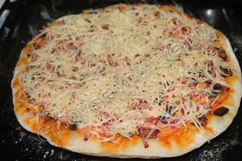 Вынимаем пиццу из духовки и посыпаем сразу сыром