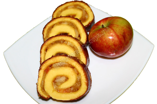 На фото кусочки аппетитного бисквитного рулета с лесными яблоками