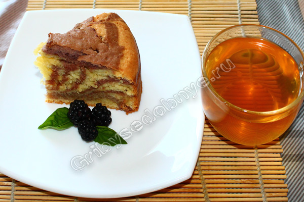 Кусочек свежеиспечённого ежевичного пирога со свежезаваренным зелёным чаем фото